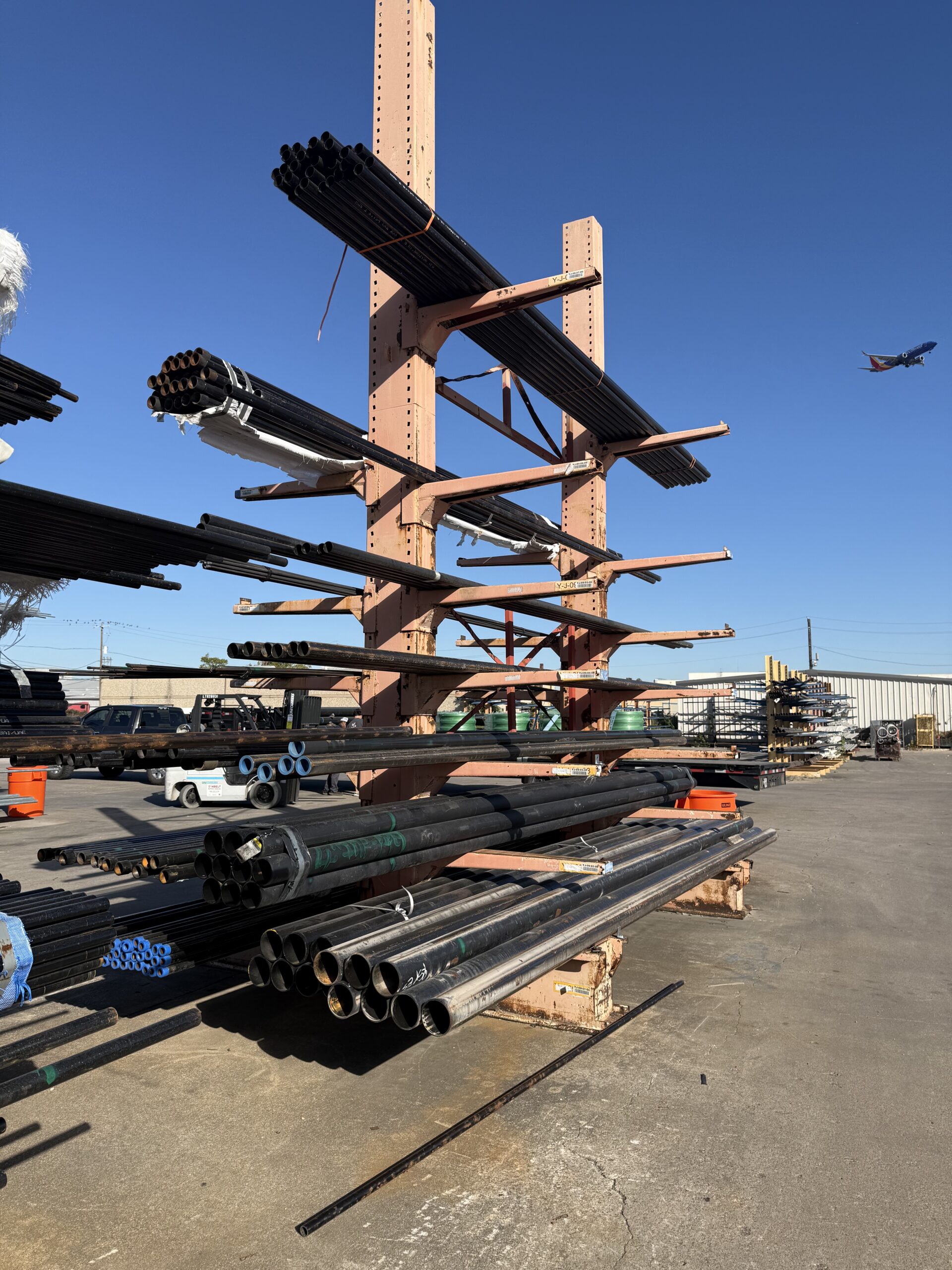 Carbon steel pipe staged on racks for process piping construction